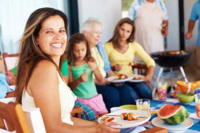 woman eating with friends and family at company picnic
